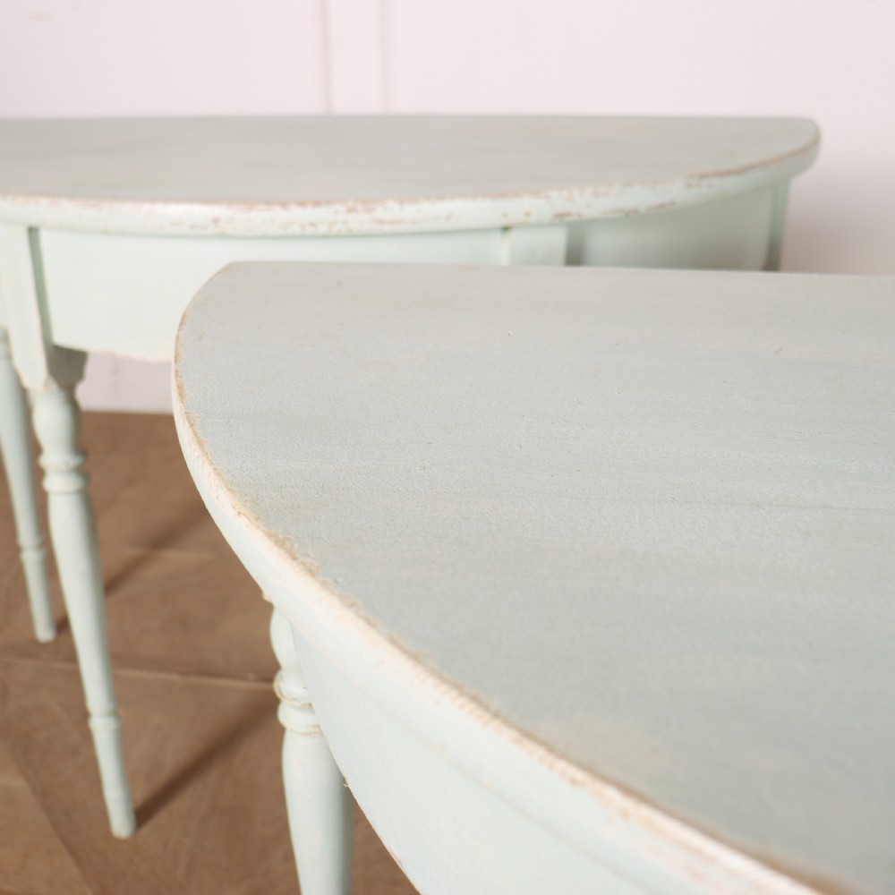 A pair of semi-circular Swedish console tables featuring pale green painted finishes, turned legs, and flat back edges. View IX