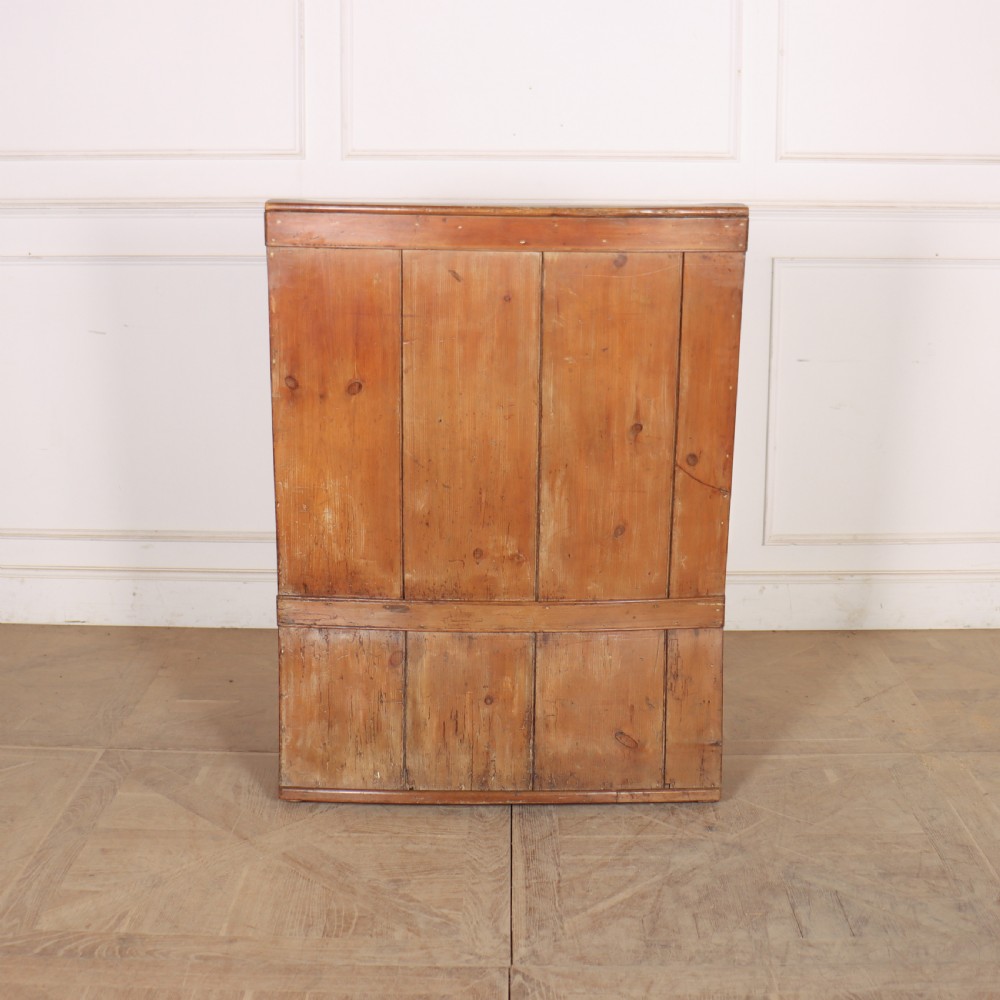 A high-backed antique pine wooden settle featuring tall vertical plank panels, curved side wings, and a floral upholstered seat cushion. View XII