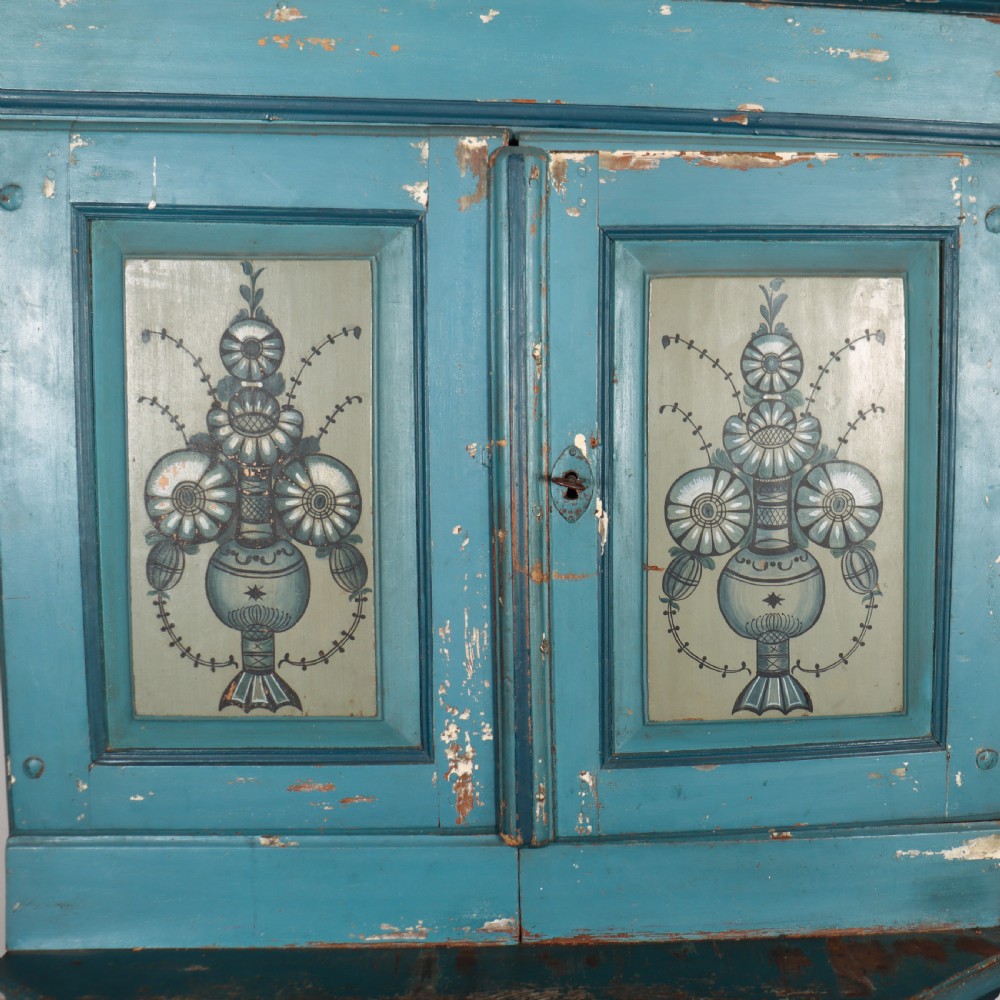 A two-tier antique Gustavian Swedish cabinet painted in blue with hand-painted urn motif panels and a dated pediment top. View IV