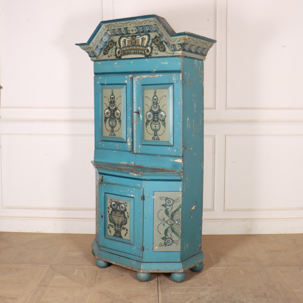 A two-tier antique Gustavian Swedish cabinet painted in blue with hand-painted urn motif panels and a dated pediment top. View VI