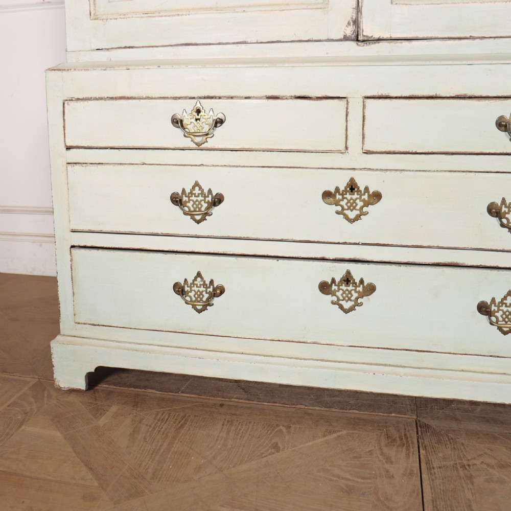 A two-piece pale blue painted timber hanging cupboard featuring panelled doors over a base with drawers and brass handles. View VI