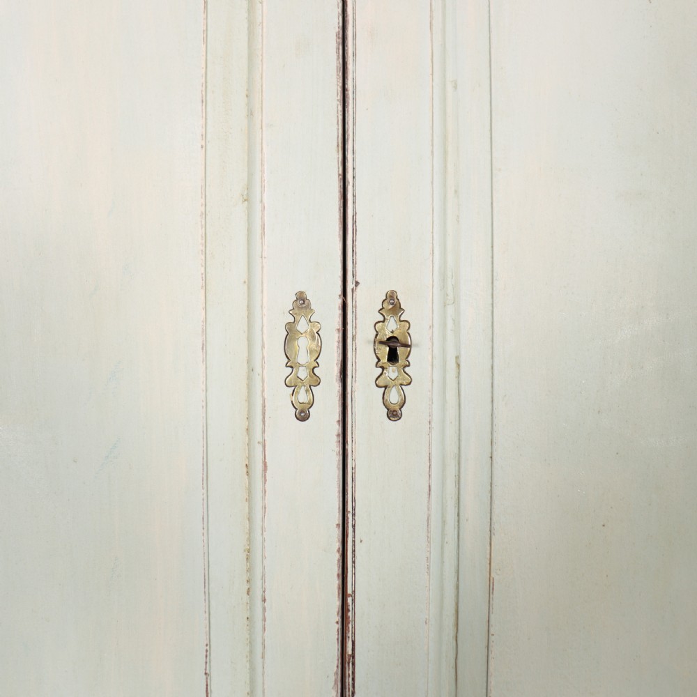 A two-piece pale blue painted timber hanging cupboard featuring panelled doors over a base with drawers and brass handles. View VII