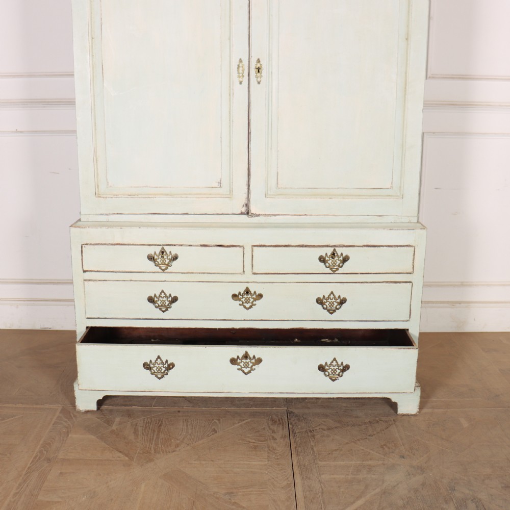 A two-piece pale blue painted timber hanging cupboard featuring panelled doors over a base with drawers and brass handles. View VIII