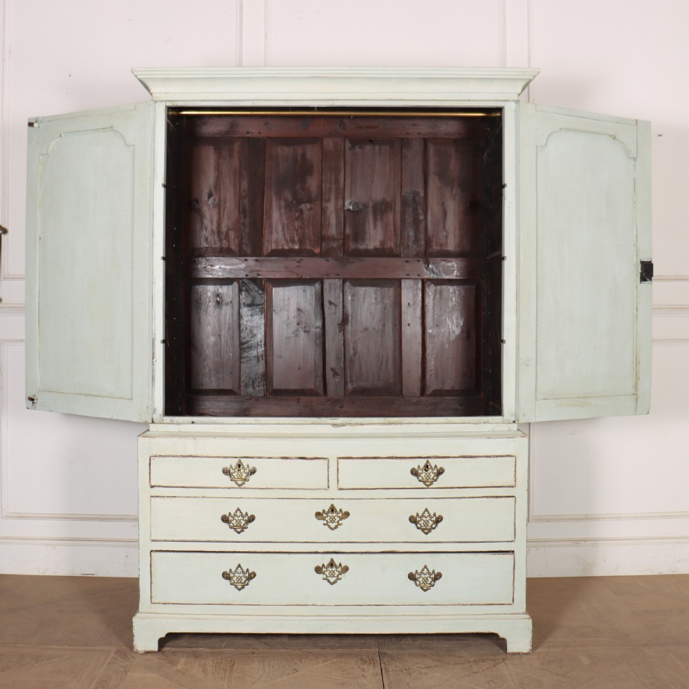A two-piece pale blue painted timber hanging cupboard featuring panelled doors over a base with drawers and brass handles. View IX