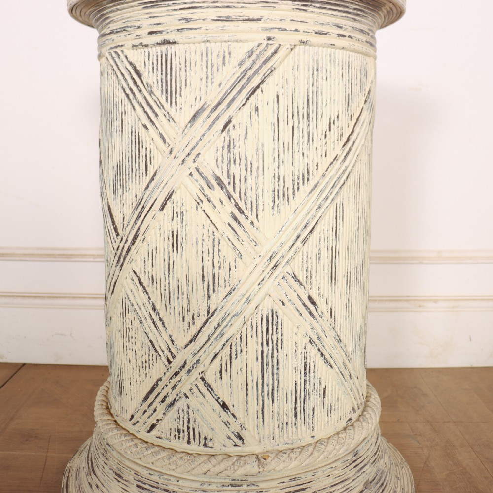 A cylindrical off-white painted wooden sculpture stand featuring carved cross-hatching patterns, a rope-twist lower border, and a distressed finish. View IV