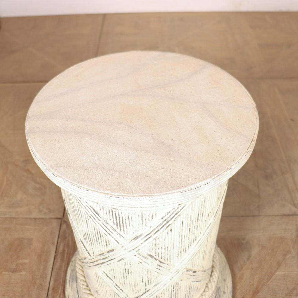 A cylindrical off-white painted wooden sculpture stand featuring carved cross-hatching patterns, a rope-twist lower border, and a distressed finish. View V