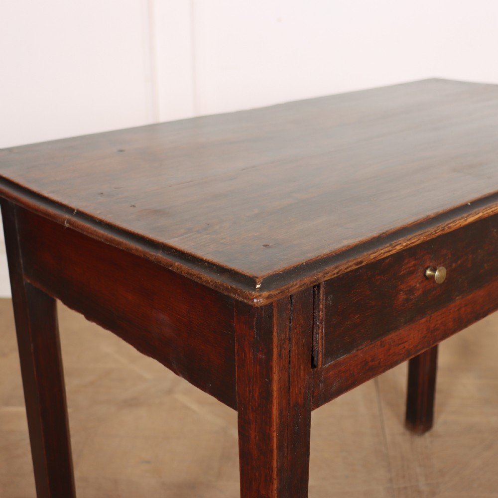 An antique dark oak lamp table featuring a single frieze drawer with brass knobs and a decorative keyhole escutcheon. View III