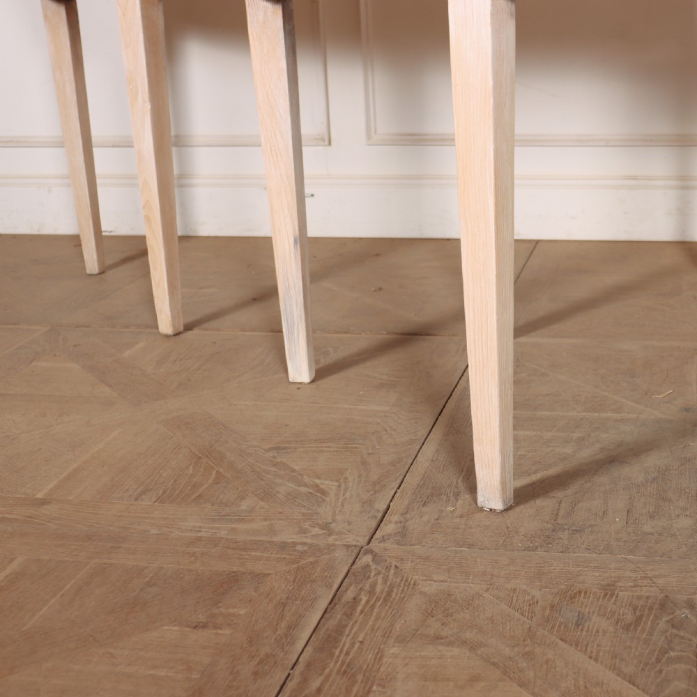 A pair of semi-circular, pale off-white painted console tables with tapered legs and flat backs designed to sit flush against a wall. View IV