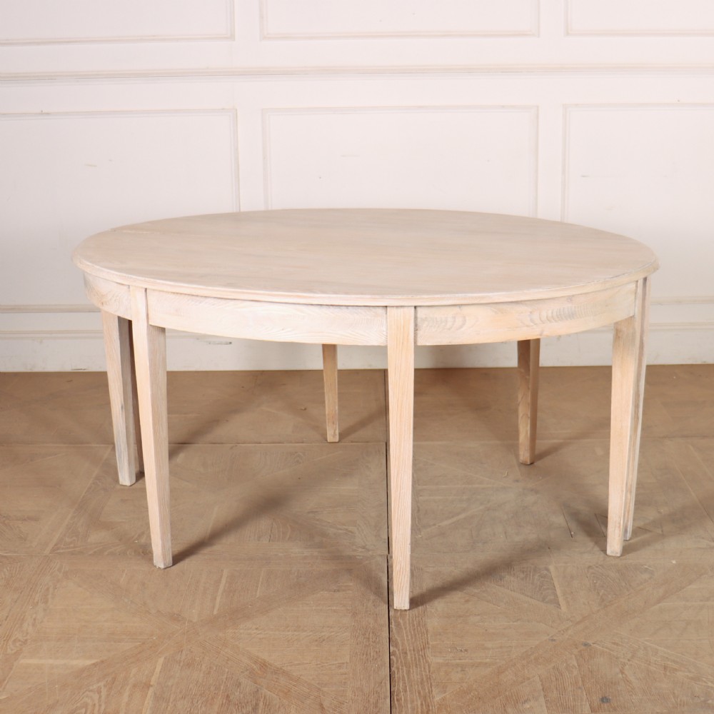 A pair of semi-circular, pale off-white painted console tables with tapered legs and flat backs designed to sit flush against a wall. View X