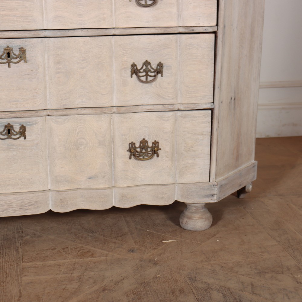 An antique Dutch glazed display cabinet with a grey-washed exterior, green painted interior, curved cresting rail, and three drawers in the base. View III
