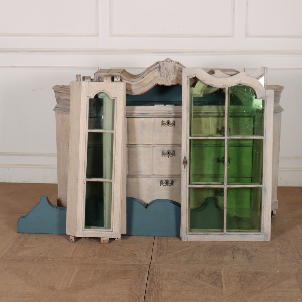 An antique Dutch glazed display cabinet with a grey-washed exterior, green painted interior, curved cresting rail, and three drawers in the base. View XIII