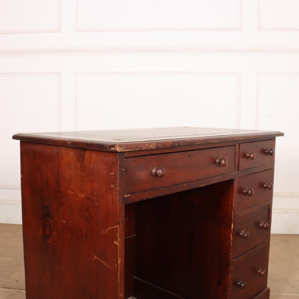 An antique mahogany childs writing desk with a green leather inset top, one wide frieze drawer, and a flight of four right-hand drawers with turned knobs. View II