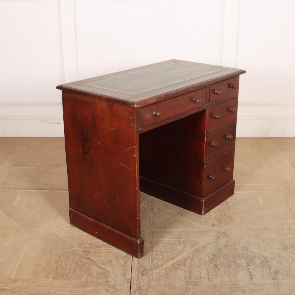 An antique mahogany childs writing desk with a green leather inset top, one wide frieze drawer, and a flight of four right-hand drawers with turned knobs. View III