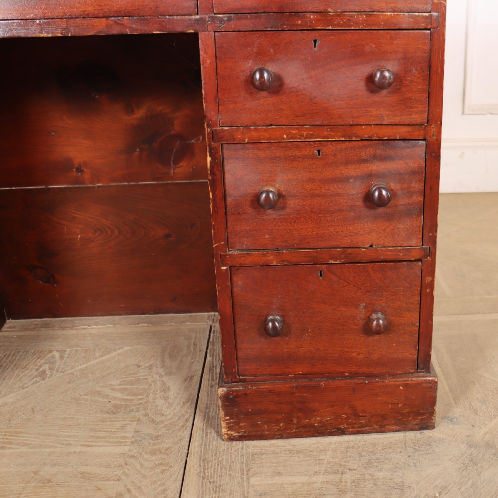 An antique mahogany childs writing desk with a green leather inset top, one wide frieze drawer, and a flight of four right-hand drawers with turned knobs. View VI