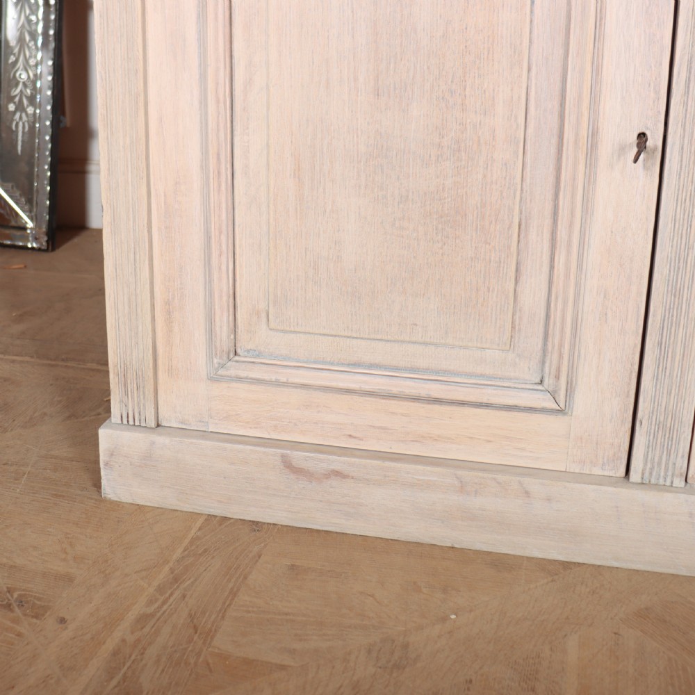 A pale English oak two-part library bookcase featuring three upper glazed doors and three lower solid panelled cupboard doors. View V