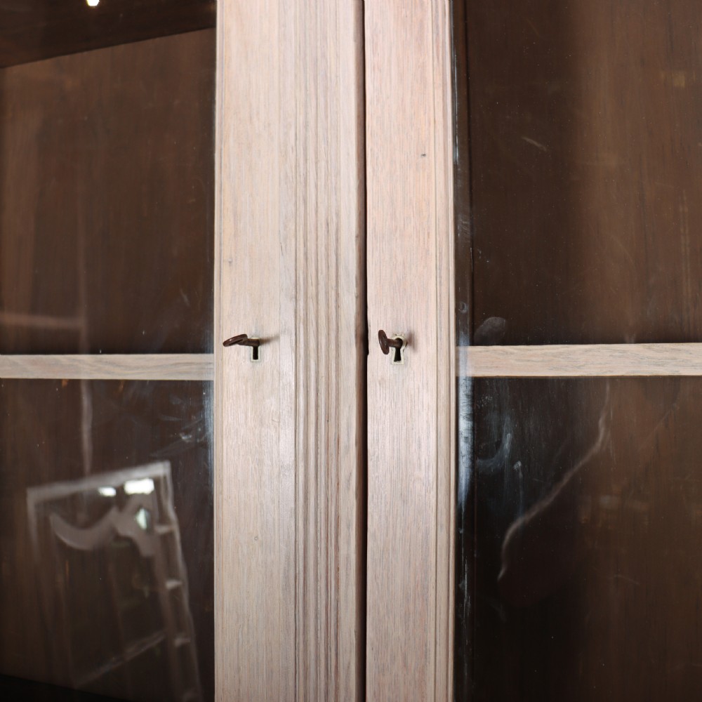 A pale English oak two-part library bookcase featuring three upper glazed doors and three lower solid panelled cupboard doors. View VIII
