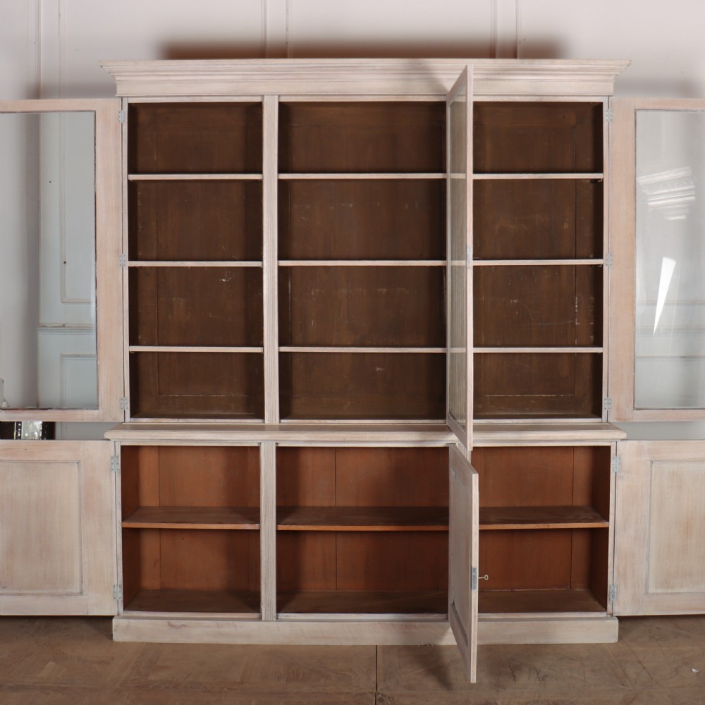A pale English oak two-part library bookcase featuring three upper glazed doors and three lower solid panelled cupboard doors. View IX