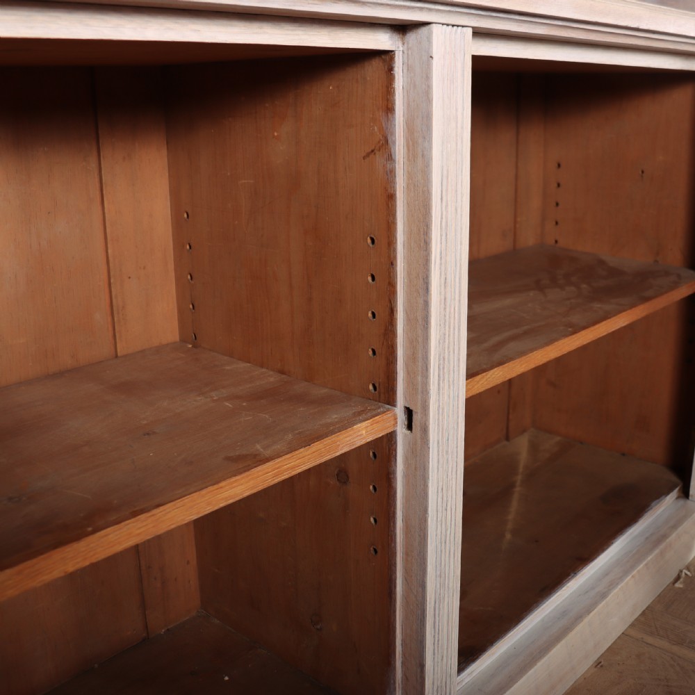 A pale English oak two-part library bookcase featuring three upper glazed doors and three lower solid panelled cupboard doors. View XI