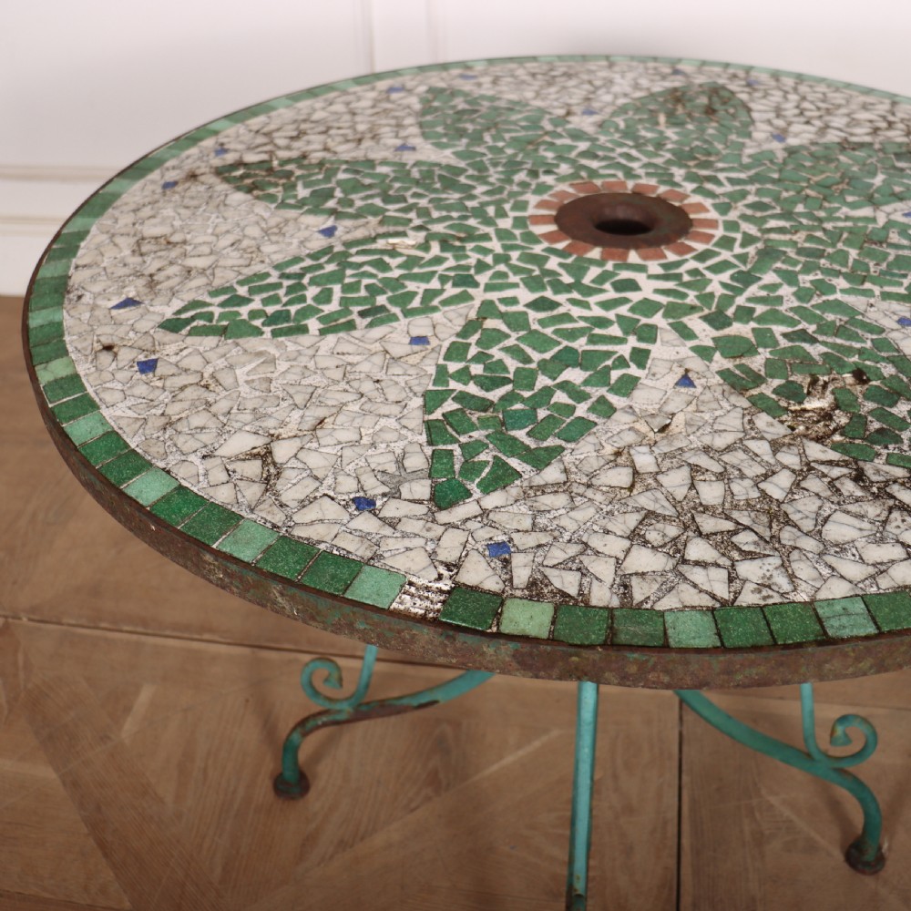 A circular garden table featuring a turquoise and off-white ceramic mosaic tile top supported by a turquoise-painted wrought iron tripod base with curved legs. View IV