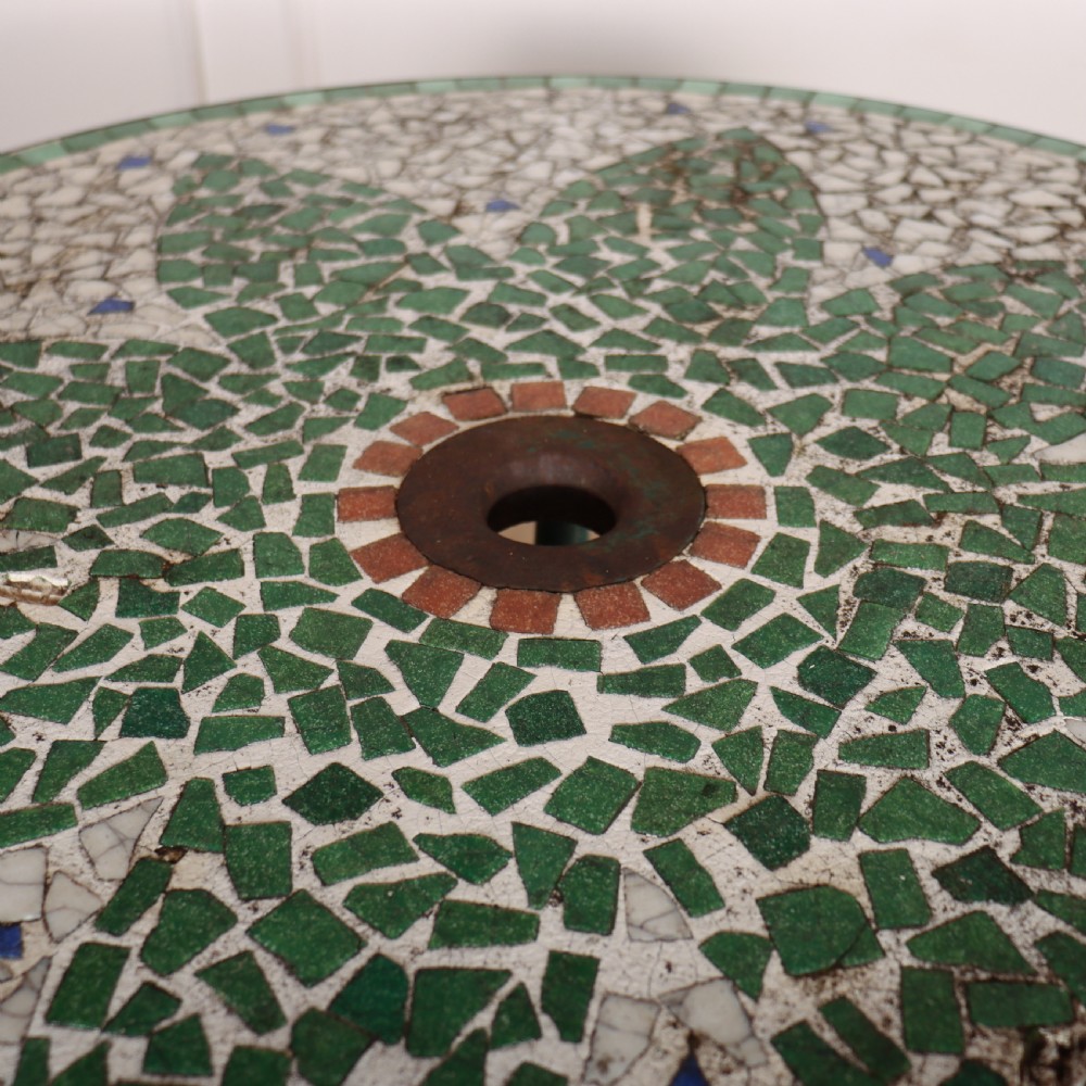 A circular garden table featuring a turquoise and off-white ceramic mosaic tile top supported by a turquoise-painted wrought iron tripod base with curved legs. View V