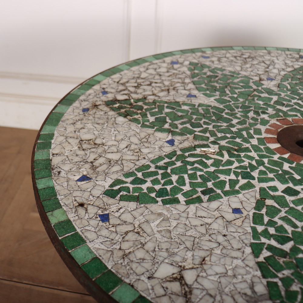 A circular garden table featuring a turquoise and off-white ceramic mosaic tile top supported by a turquoise-painted wrought iron tripod base with curved legs. View VII
