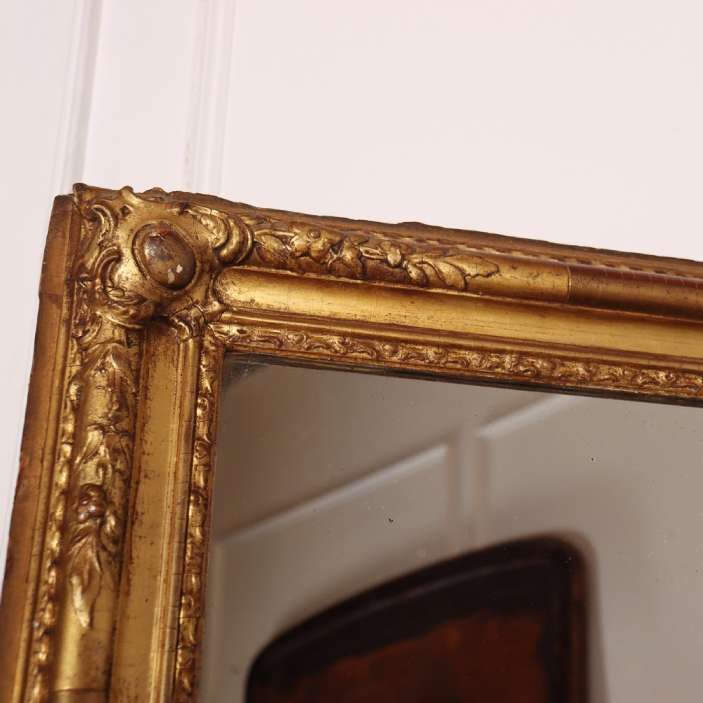 A large rectangular French antique mirror featuring a gold gilded frame with beaded moulding and carved corner details. View VII