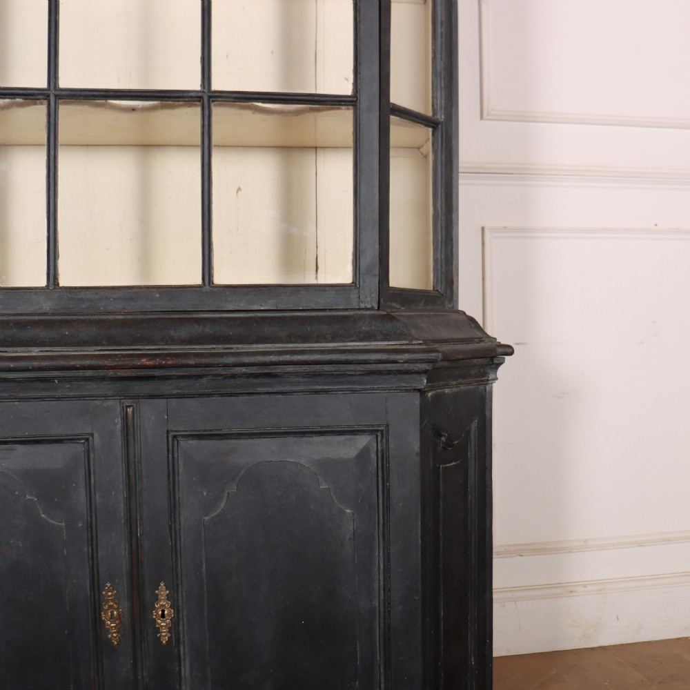 A tall, dark charcoal grey painted Dutch vitrine cabinet featuring a shaped bonnet top, glazed upper doors with curved astragal glazing bars, a cream interior, and panelled double lower doors. View VII
