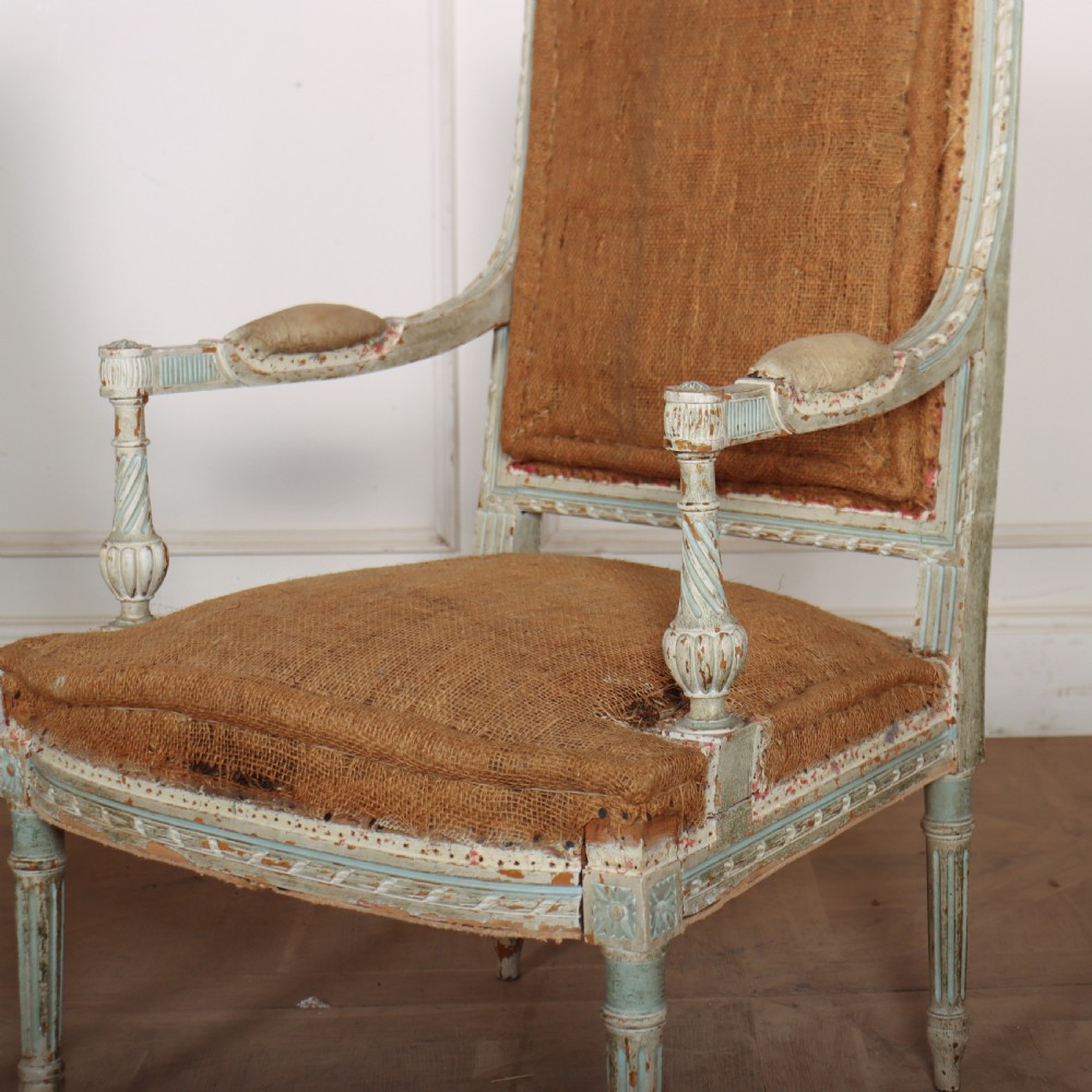 A pair of antique French Louis XVI open armchairs featuring carved, distressed light blue painted frames, fluted legs, and exposed hessian upholstery. View VI
