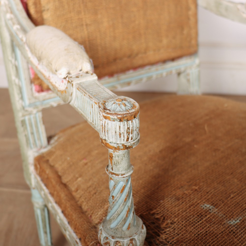 A pair of antique French Louis XVI open armchairs featuring carved, distressed light blue painted frames, fluted legs, and exposed hessian upholstery. View VIII