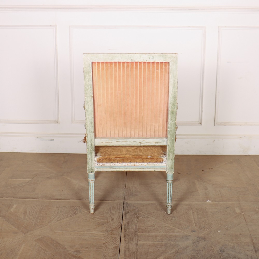 A pair of antique French Louis XVI open armchairs featuring carved, distressed light blue painted frames, fluted legs, and exposed hessian upholstery. View IX