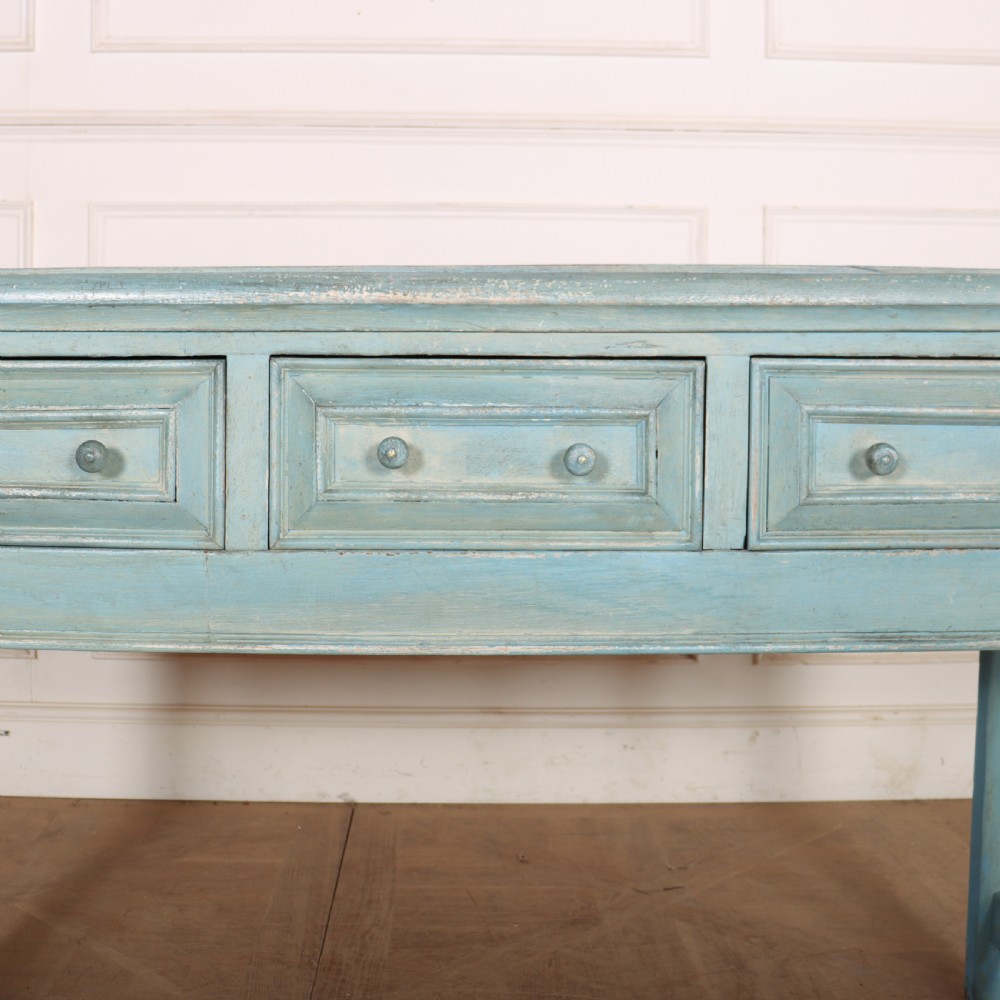 A pale blue painted wooden dresser base featuring three inline drawers with small wooden knobs and turned front legs connected by a low stretcher. View VI
