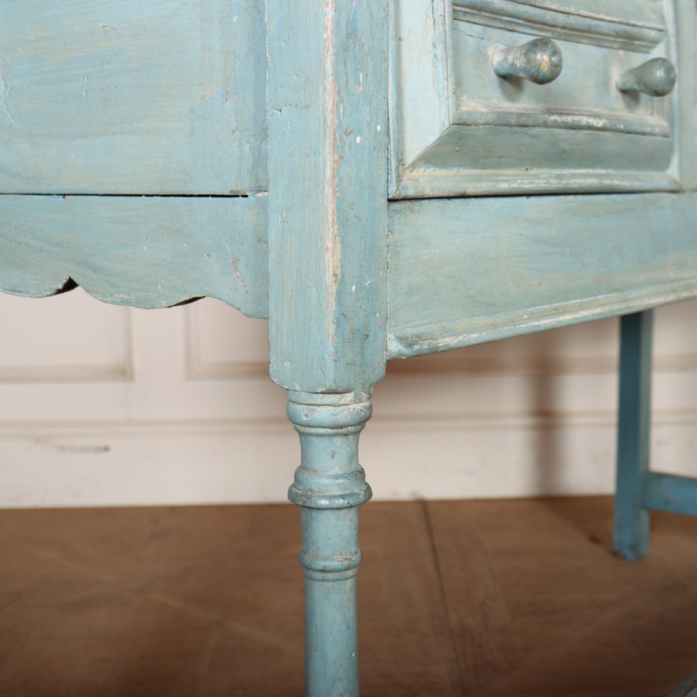 A pale blue painted wooden dresser base featuring three inline drawers with small wooden knobs and turned front legs connected by a low stretcher. View IX