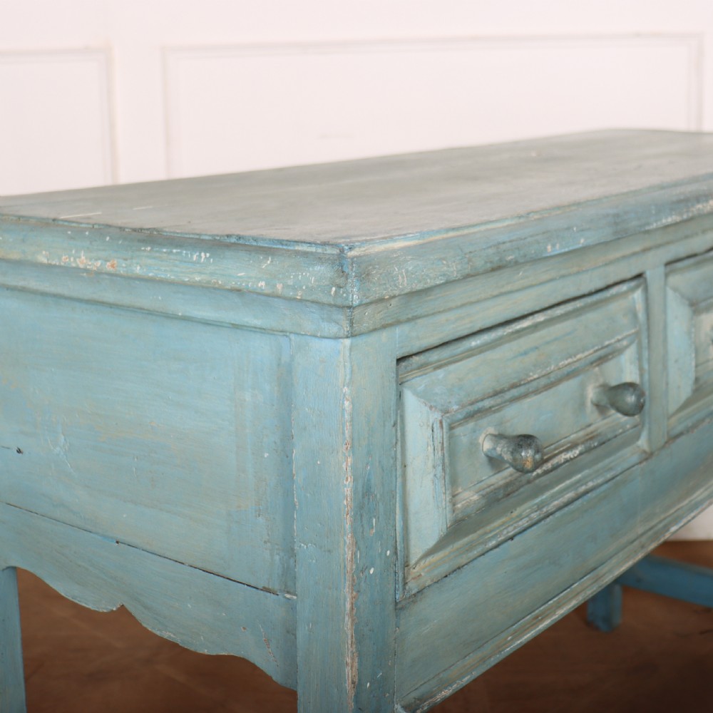 A pale blue painted wooden dresser base featuring three inline drawers with small wooden knobs and turned front legs connected by a low stretcher. View X