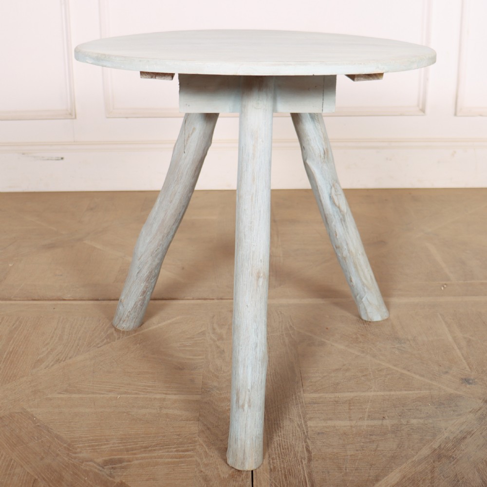 A circular three-legged English cricket table with a pale blue-grey painted finish.