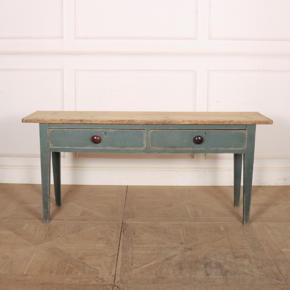 An antique Scottish console table featuring a muted green painted base with two drawers, dark wooden turned knobs, square tapered legs, and a natural pine top.