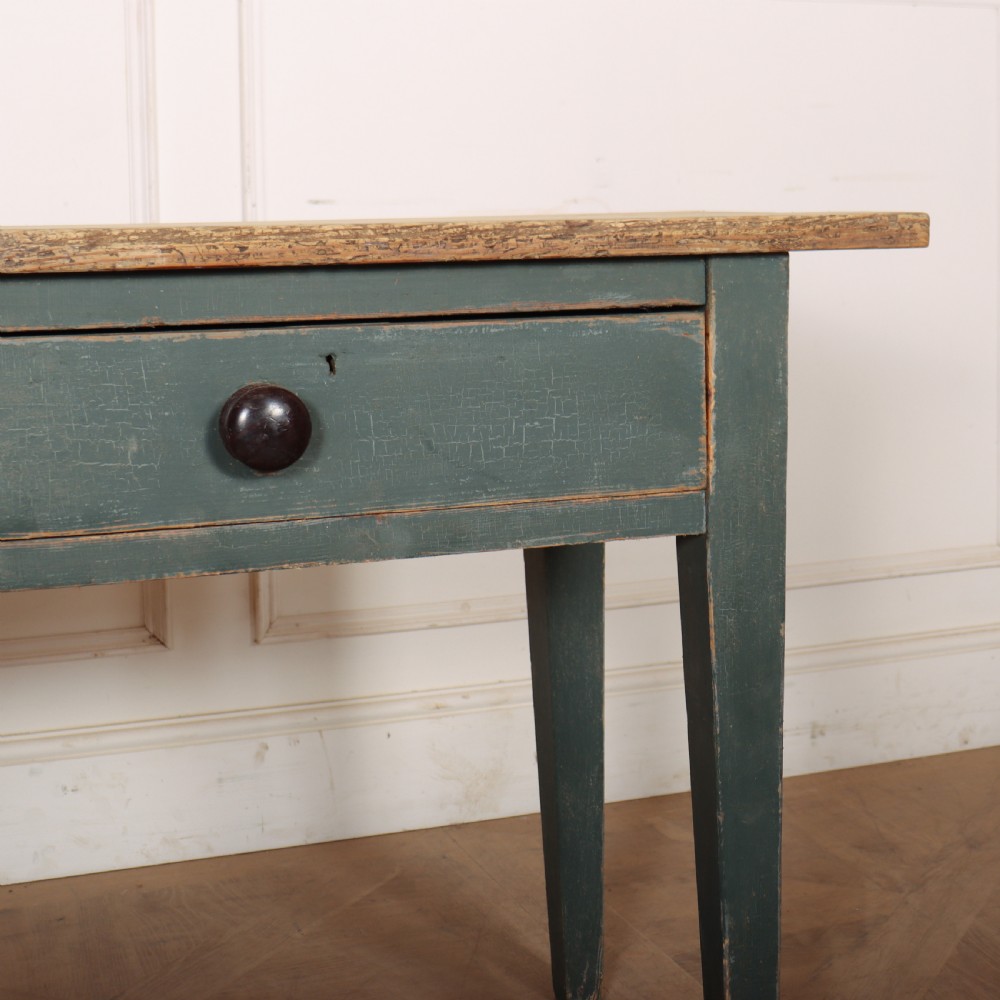 An antique Scottish console table featuring a muted green painted base with two drawers, dark wooden turned knobs, square tapered legs, and a natural pine top. View IV