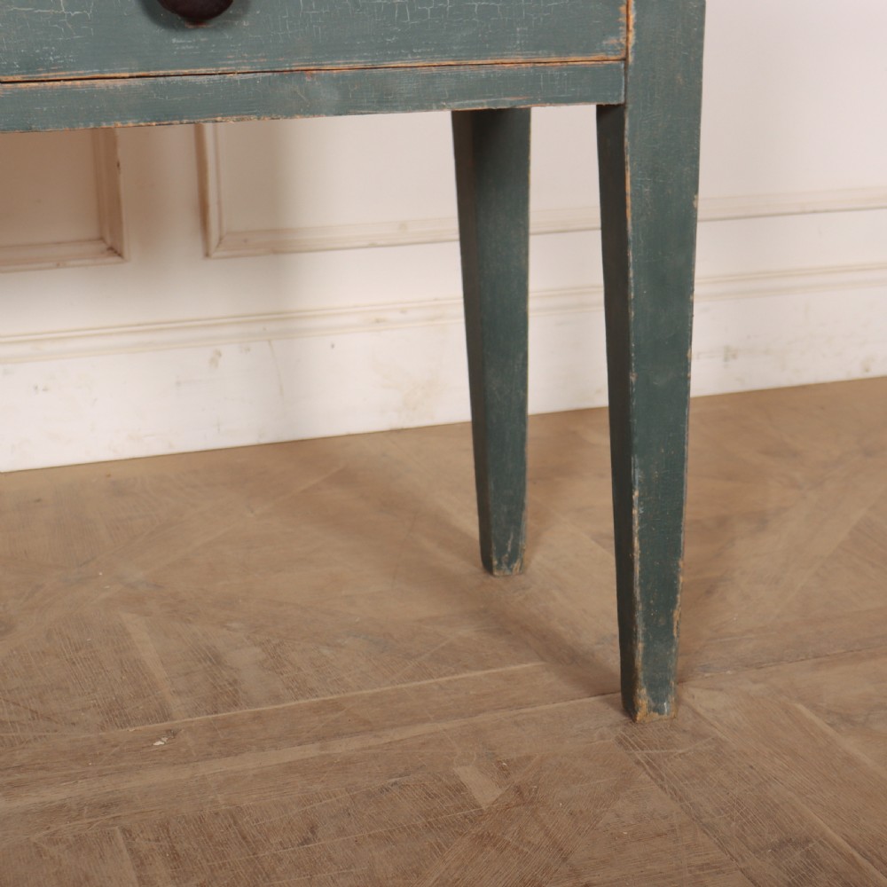 An antique Scottish console table featuring a muted green painted base with two drawers, dark wooden turned knobs, square tapered legs, and a natural pine top. View V