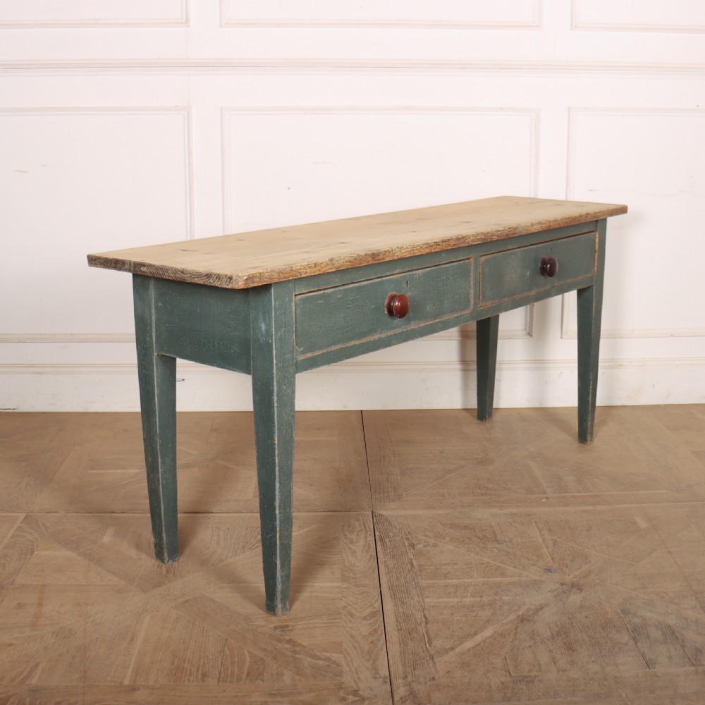 An antique Scottish console table featuring a muted green painted base with two drawers, dark wooden turned knobs, square tapered legs, and a natural pine top. View VII