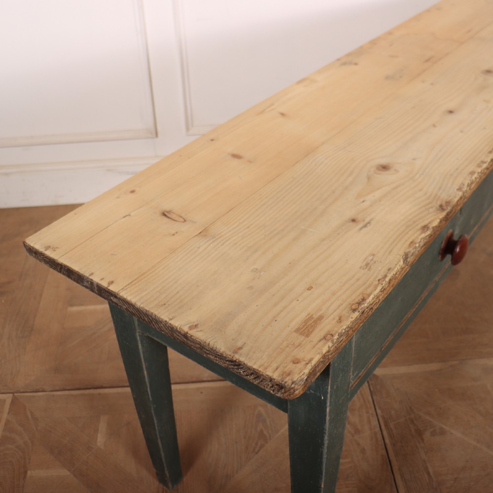 An antique Scottish console table featuring a muted green painted base with two drawers, dark wooden turned knobs, square tapered legs, and a natural pine top. View IX