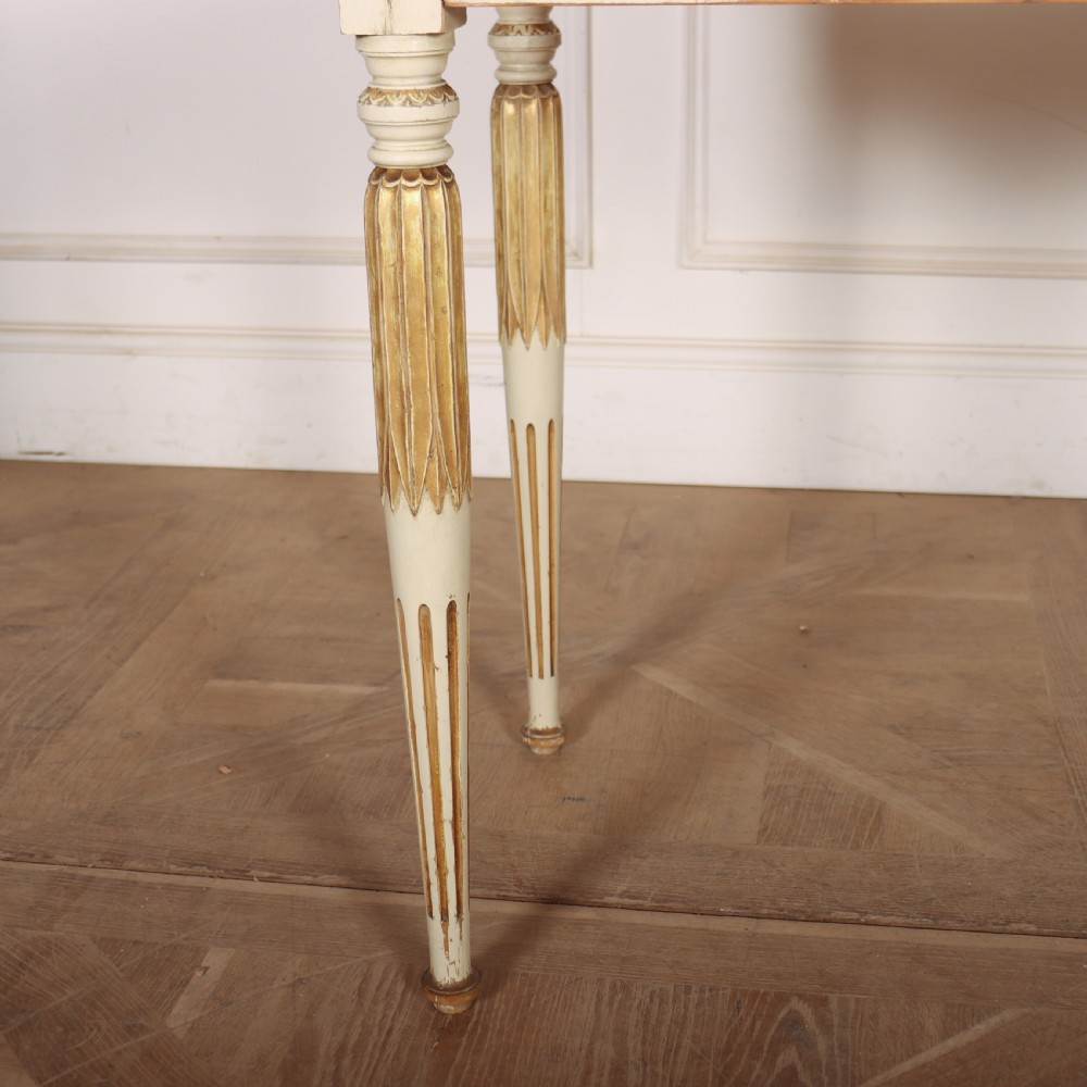 An off-white painted Swedish side table featuring a white marble top, fluted frieze with a central drawer knob, and tapered fluted legs with gilded accents. View IV