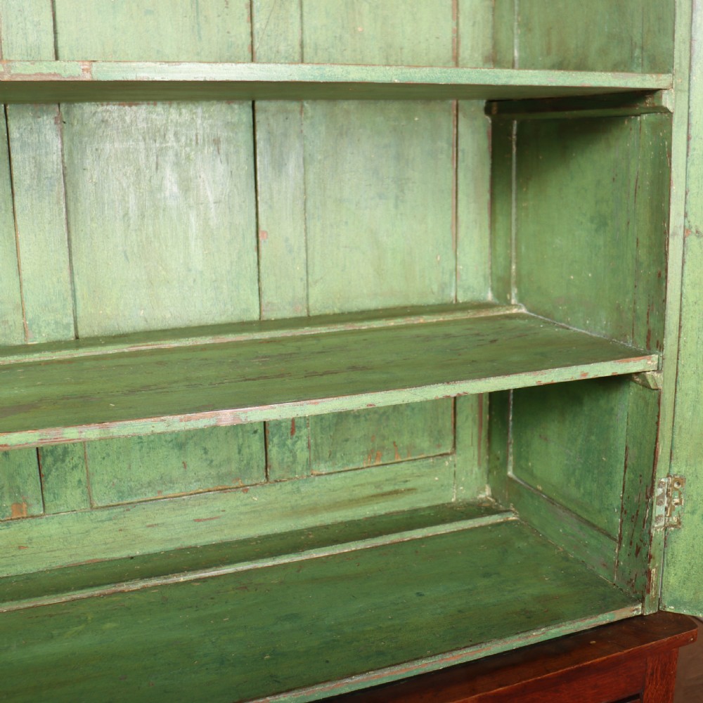 A large two-part oak kitchen dresser with a glazed upper section featuring a green painted interior above a base with five drawers and two panelled cupboard doors. View VII