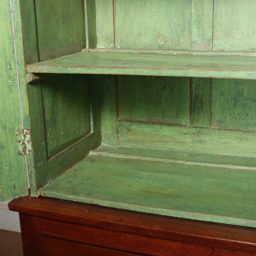 A large two-part oak kitchen dresser with a glazed upper section featuring a green painted interior above a base with five drawers and two panelled cupboard doors. View VIII