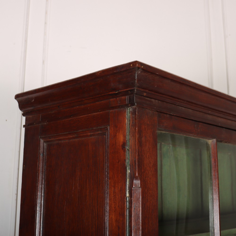 A large two-part oak kitchen dresser with a glazed upper section featuring a green painted interior above a base with five drawers and two panelled cupboard doors. View XI