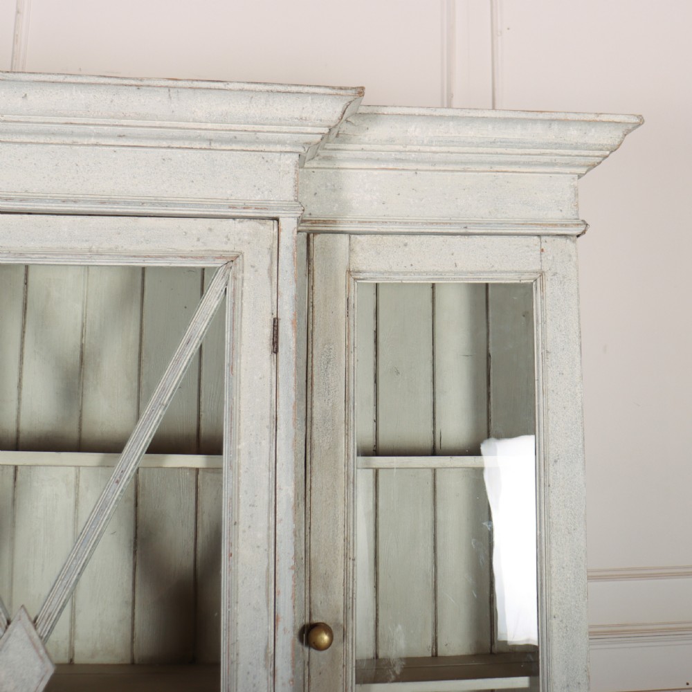 A painted off-white breakfront kitchen dresser featuring glazed upper doors, a central X-mullion door, three drawers, and lower wire mesh cupboards. View III