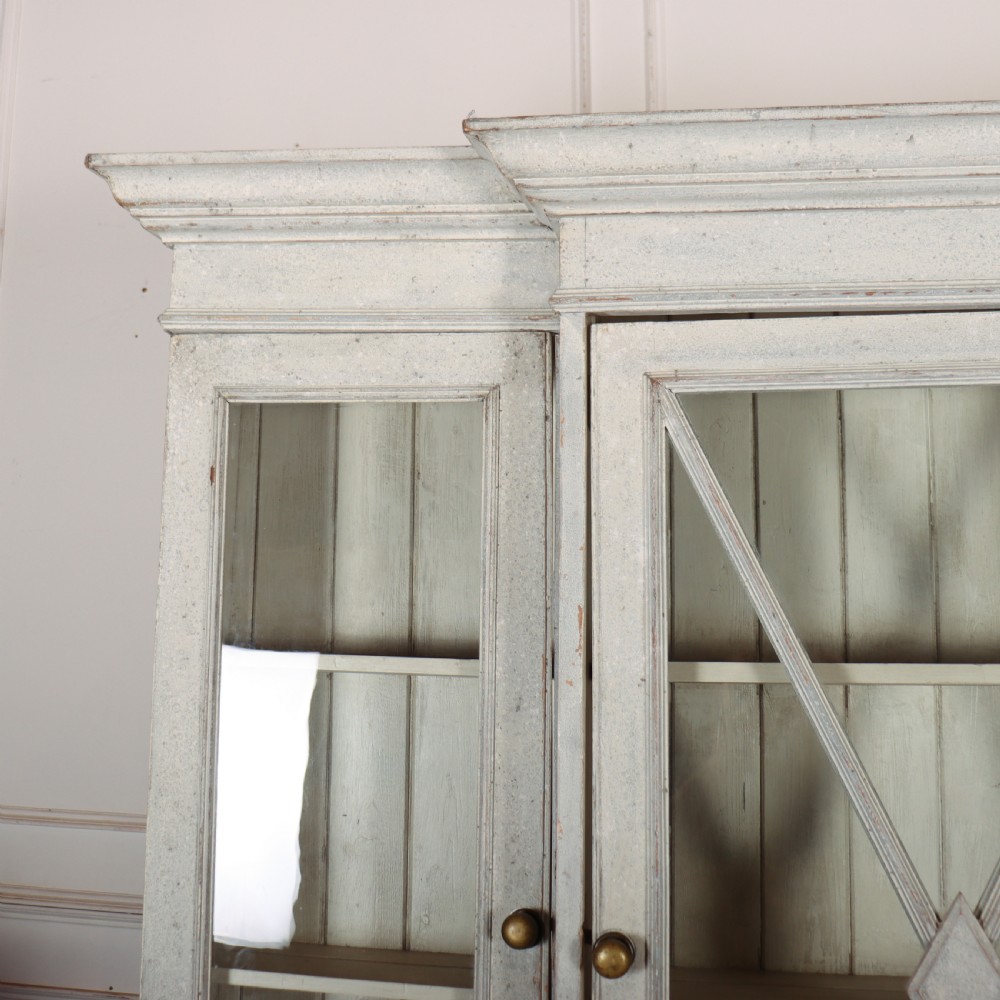A painted off-white breakfront kitchen dresser featuring glazed upper doors, a central X-mullion door, three drawers, and lower wire mesh cupboards. View VI