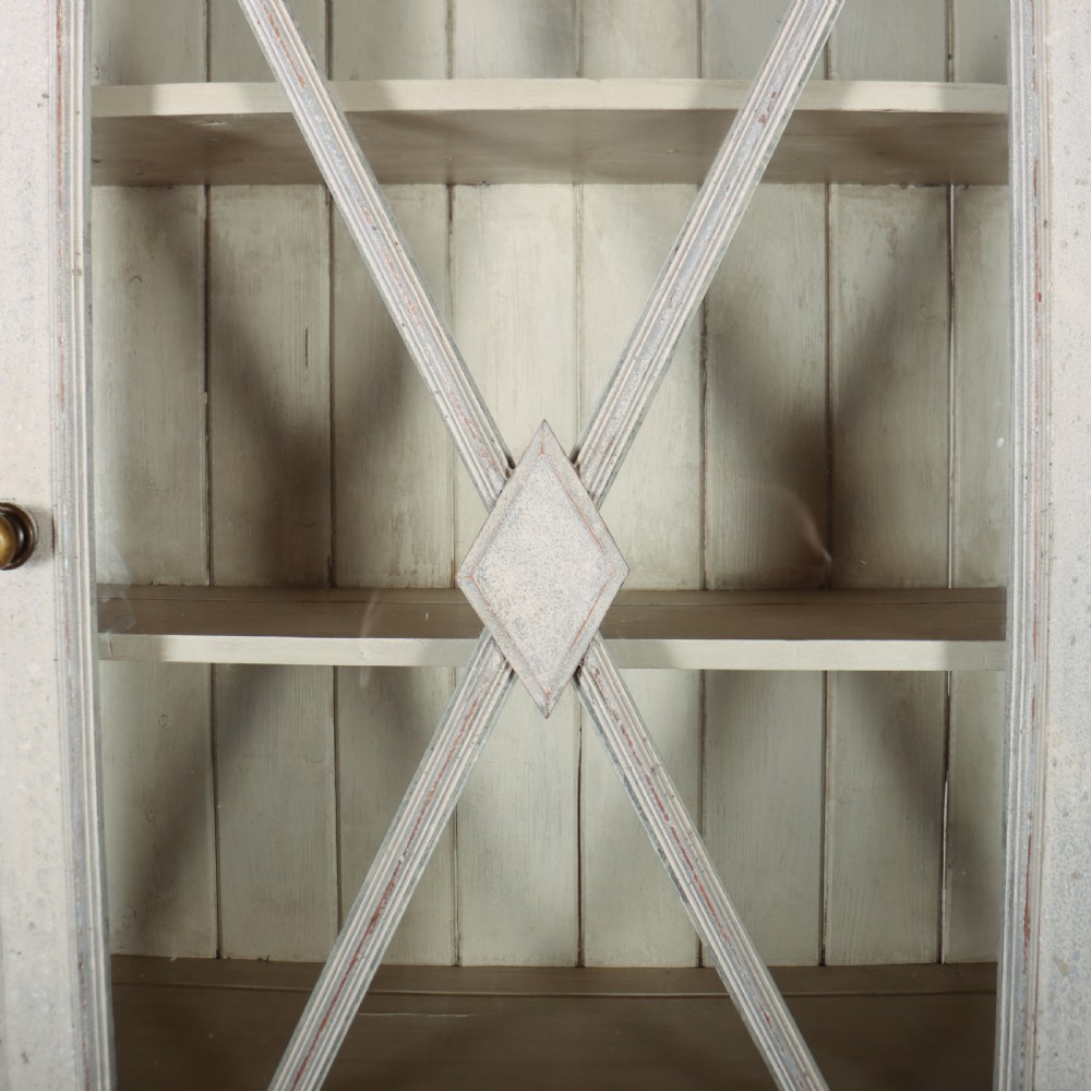 A painted off-white breakfront kitchen dresser featuring glazed upper doors, a central X-mullion door, three drawers, and lower wire mesh cupboards. View VII