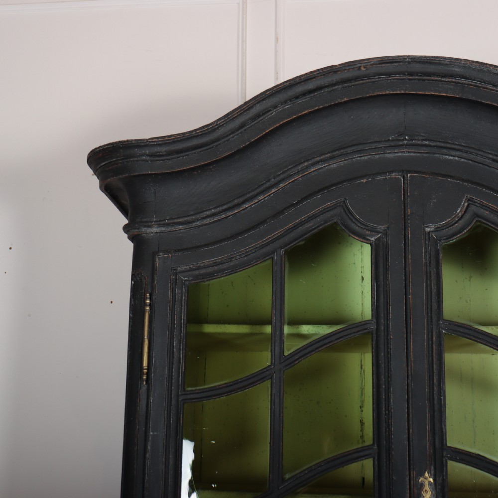 A two-piece black painted Dutch cabinet featuring arched glazed upper doors with wavy astragal bars, a green interior, and solid double doors below. View II