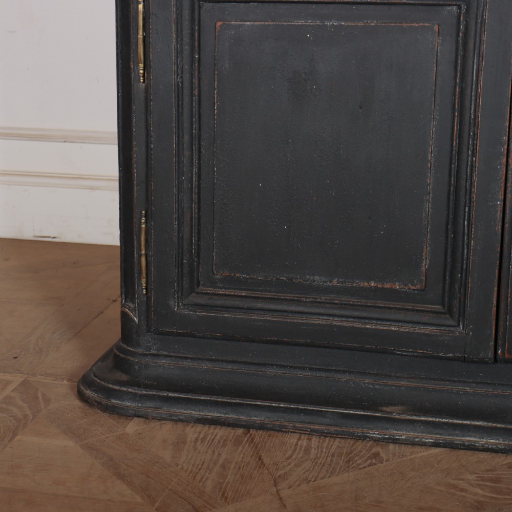 A two-piece black painted Dutch cabinet featuring arched glazed upper doors with wavy astragal bars, a green interior, and solid double doors below. View VII