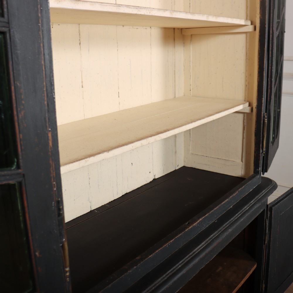 A two-piece black painted Dutch cabinet featuring arched glazed upper doors with wavy astragal bars, a green interior, and solid double doors below. View XI