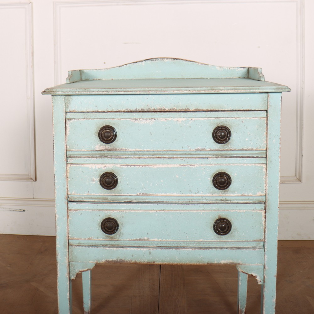 A pale blue painted three-drawer antique bedside cabinet featuring dark round knobs and a low gallery top. View II